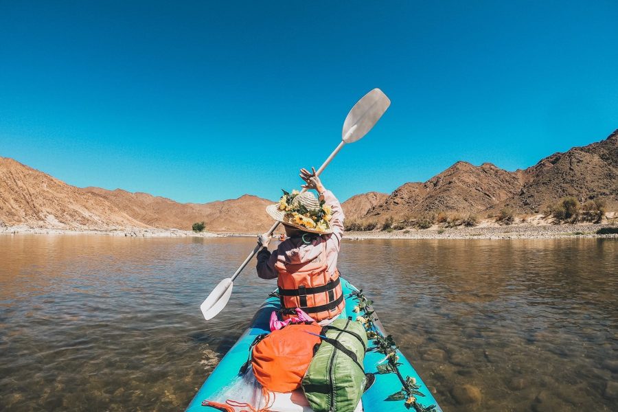 A woman on a rafting trip, paddling along the river.